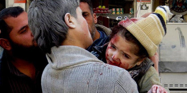 This photo provided by the anti-government activist group Aleppo Media Center (AMC), which has been authenticated based on its contents and other AP reporting, shows a Syrian man carrying a wounded child following a Syrian government airstrike in Aleppo, Syria, Monday, Feb. 3, 2014. Syrian government helicopters and warplanes unleashed a wave of airstrikes on more than a dozen opposition-held neighborhoods in the northern city of Aleppo on Sunday, firing missiles and dropping crude barrel bombs in a ferocious attack that killed at least 36 people, including children, activists said. (AP Photo/Aleppo Media Center, AMC)