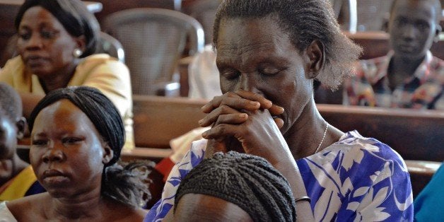 People attend a mass in Juba on December 15, 2014 to commemorate one year since the outbreak of the South Sudan civil war. From a 14-month old toddler to a 105-year old grandmother : the first names of some of the tens of thousands killed in South Sudan since civil war began a year ago were released on December 15, 2014. With no official toll, South Sudanese civil society volunteers have spent months collecting, cross checking and confirming the names of those killed. AFP PHOTO/SAMIR BOL (Photo credit should read SAMIR BOL/AFP/Getty Images)