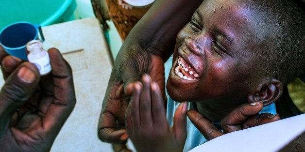 A child smiles as he prepares to receive a dose of oral cholera vaccine inside a tent of the United Nation Mission in South Sudan (UNMISS), at their Tongping base in the South Sudan capital, Juba, on March 1, 2014. Limited water supplies, poor sanitary conditions and a high level of congestion led to a mass oral cholera vaccination campaign. AFP PHOTO / ANDREI PUNGOVSCHI (Photo credit should read ANDREI PUNGOVSCHI/AFP/Getty Images)