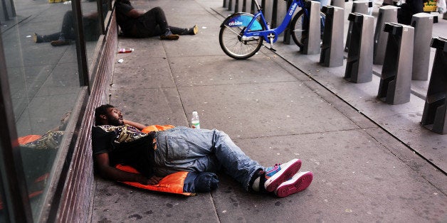 NEW YORK, NY - AUGUST 21: A man sleeps on the ground outside the Port Authority Bus Terminal on August 21, 2014 in New York City. The Port Authority Bus Terminal, which opened in 1950, is New York City's largest bus depot and has long been derided as dirty and inefficient. Leaking ceilings, unsanitary bathrooms, late buses and a long standing problem with the homeless have added to the terminals reputation. While many commuters and transportation advocates are rallying for a new terminal, the Port Authority of New York and New Jersey has announced that they agency plan to spend up to $260 million on maintenance in the coming years. (Photo by Spencer Platt/Getty Images)