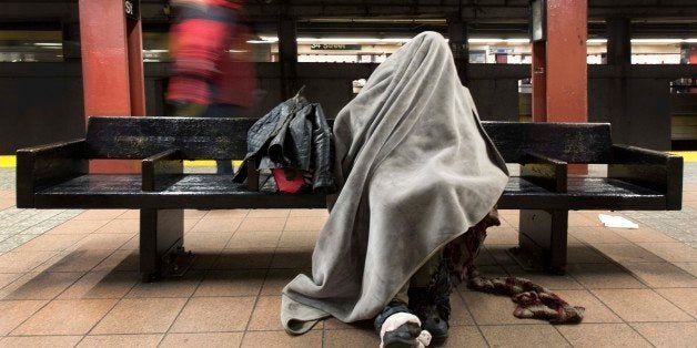 A homeless man rests under a blanket while sitting on a bench in a New York subway station, Tuesday, Jan. 28, 2014. Monday night volunteers spread throughout the city to do an annual count of homeless people living on the streets. According to advocacy group Coalition for the Homeless, more than 50,000 people live in municipal homeless shelters, with thousands more living on the streets. (AP Photo/Mark Lennihan)