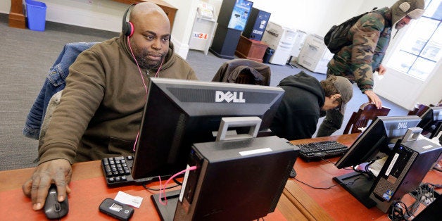 In this Feb. 19, 2015 photo, Jeffery Bailey, left, works at a public computer at the Nashville Public Library in Nashville, Tenn. Although Bailey sleeps in a tent in a churchyard during the night, he spends his days surfing the Internet, reading, and enjoying music and movies at the library. (AP Photo/Mark Humphrey)