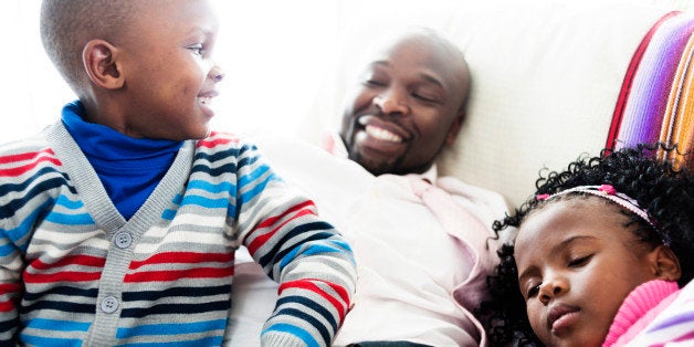 Happy father and childen on a couch at home