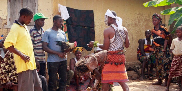 In this photo taken on Feb. 23, 2015, traditional healers, center, take part in a exorcism as villagers hand them a chicken,