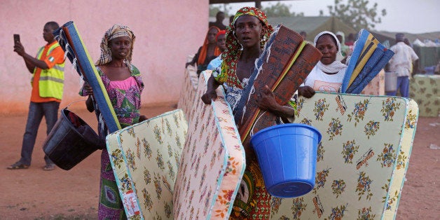 FILE - In this file photo taken on Thursday Nov. 27, 2014, civilians who fled their homes following an attack by Islamist militants, in North East Nigeria walk away after receiving relief materials from the government at the camp for internally displaced people in Yola, Nigeria. Islamic extremists are rampaging through villages in northeast Nigeria's Adamawa state, killing, burning and looting with no troops deployed to protect civilians, fleeing villagers said Wednesday, Jan. 28, 2015. (AP Photo/Sunday Alamba,File)