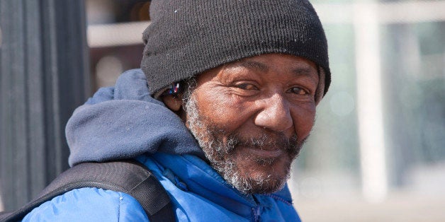 Happy homeless african american man outdoors during the day.