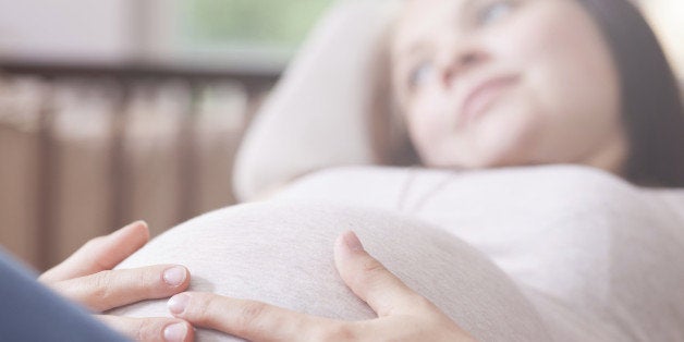 Pregnant Girl is laying in a chair and dreaming about her pregnancy.