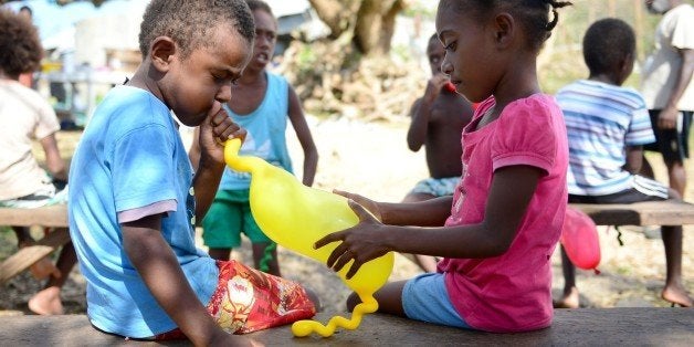 Children play with balloons that were part of a small relief package arranged by an Australian aid donor in the village of Saama, 76 kilometres north of Vanuatu's capital Port Vila on March 21, 2015 after Cyclone Pam ripped through the island nation. Severe Tropical Cyclone Pam, a maximum category five storm, destroyed homes and crops and contaminated water supplies in the Pacific archipelago when it hit on March 13, increasing the risk of the spread of infectious and water-borne diseases. AFP PHOTO/Jeremy PIPER (Photo credit should read JEREMY PIPER/AFP/Getty Images)