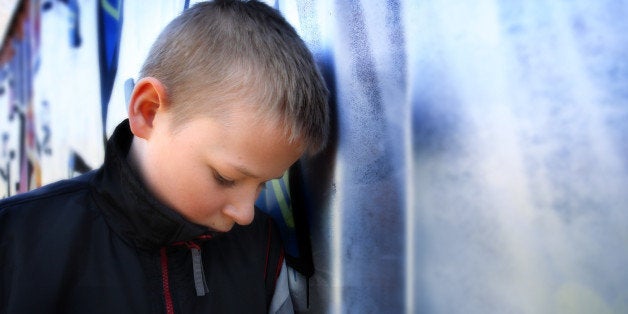 upset boy against a wall