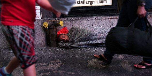 NEW YORK, NY - AUGUST 22: A homeless man sleeps on a Manhattan street on August 22, 2014 in New York City. According to the Department of Homeless Services, the number of homeless people in New York City has risen by more than 20,000 over the past five years. Newly elected Mayor Bill de Blasio, who ran as a liberal, has released a $41 billion plan to create 200,000 units of affordable housing across the city. Critics say the plan is too far off and that more immediate solutions need to be implemented to halt the increase of homelessness. (Photo by Spencer Platt/Getty Images)