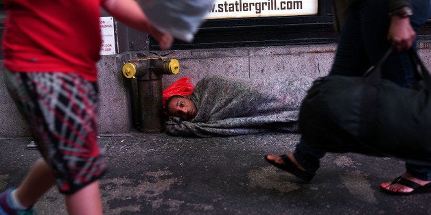 NEW YORK, NY - AUGUST 22: A homeless man sleeps on a Manhattan street on August 22, 2014 in New York City. According to the D