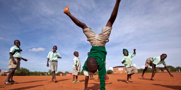 In this photo taken Wednesday, Nov. 21, 2012, a young schoolboy makes handstands as he plays with others during break in the