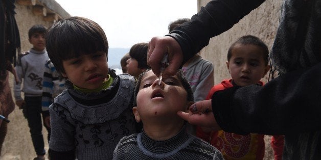 An Afghan health worker administers polio vaccine drops to a child on the second day of a vaccination campaign in Kabul on March 16, 2015. Nearly nine million children throughout Afghanistan will be immunized during a three-day national polio immunization drive launched on March 15.The immunization campaign comes shortly after Afghanistan reported its first case of polio virus for 2015, in Helmand, in the Southern Region. Afghanistan and Pakistan are the only two countries in the world to have reported cases of the crippling polio virus in the past eight months and it is increasingly likely that these are the last two countries on Earth with active polio transmission. AFP PHOTO / SHAH Marai (Photo credit should read SHAH MARAI/AFP/Getty Images)