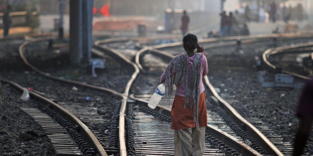 An Indian woman walks after defecating on a railway track, on World Toilet Day in Gauhati, India, Wednesday, Nov. 19 2014. India is considered to have the world's worst sanitation record despite spending some $3 billion since 1986 on sanitation programs, according to government figures. Building toilets in rural India, where hundreds of millions are still defecating outdoors, will not be enough to improve public health, according to a study published last month. (AP Photo/Anupam Nath)