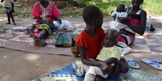 A girl holds her younger brother who is currently treated for malaria and dehydration at the Al Sabbah Children's hospital in Juba on October 14, 2014. The government of South Sudans integrated response to the nutrition emergency, the South Sudan National and State Ministry of Health, Sanitation and Environment, UNICEF and WFP are starting a mass-screening campaign to reach over 600,000 children in high-burden, non-conflict affected states - Juba, Warrap and Northern Bahr-Ghazal. AFP PHOTO//CHARLES LOMODONG (Photo credit should read CHARLES LOMODONG/AFP/Getty Images)