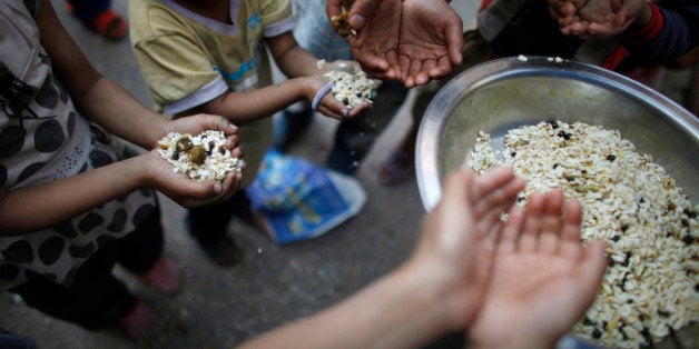 A Nepalese devotee distributes a Newari food called Samaybaji, a mixture of beaten rice, black soybean, onion, ginger and meat prepared for religious rituals during the Panch Areh chariot festival at Ashon in Katmandu, Nepal, Thursday, April 11, 2013. Three different chariots of Hindu deities Kankeshwori, Shankata and Bhadrakali are taken through the streets during the festival celebrated by Nepalâs Newar Community. (AP Photo/Niranjan Shrestha)