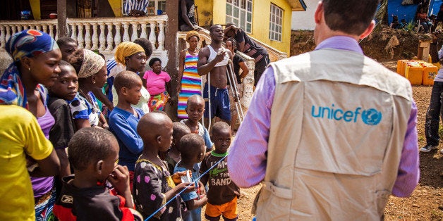 In this photo taken on Thursday, Feb. 26, 2015, A UNICEF aid worker, right, visits a home that has been quarantined due to