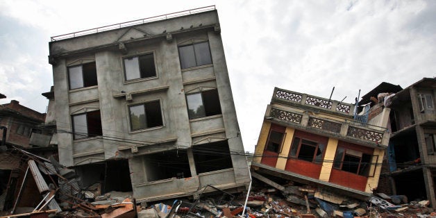A Nepalese man walks past damaged buildings in Lalitpur, on the outskirts of Kathmandu, Nepal, Thursday, April 30, 2015. In m