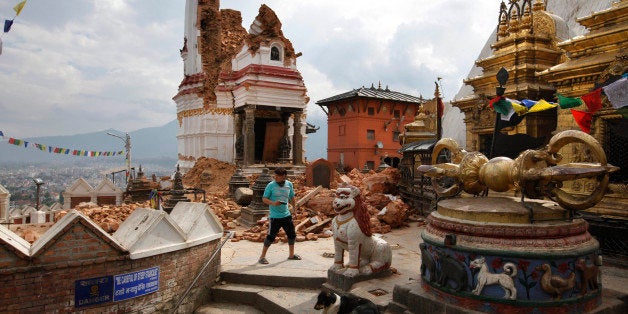 In this Thursday, April 30, 2015 photo, a man walks through the famous Swayambhunath stupa after it was damaged in the April 25 massive earthquake in Kathmandu, Nepal. Swayambhunath, which dates back to the 5th century, is one of at least 68 cultural heritage sites in Nepal that were damaged by the earthquake. (AP Photo/Niranjan Shrestha)