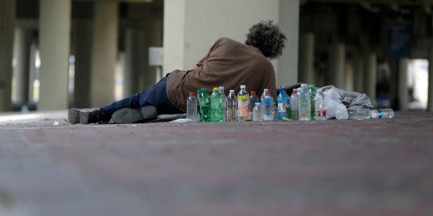 A homeless man lies under the Pontchartrain Expressway overpass, where up to 150 homeless live, in New Orleans on Wednesday, Aug. 13, 2014. The cityâs health department put up notices Monday giving the estimated 150 homeless people 72 hours to leave the area, citing health hazards. (AP Photo/Gerald Herbert)