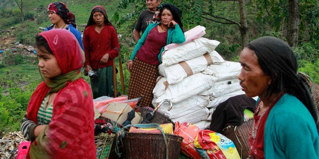 Villagers wait for relief aid in the destroyed village of Balua, near the epicenter of Saturday's massive earthquake, in the