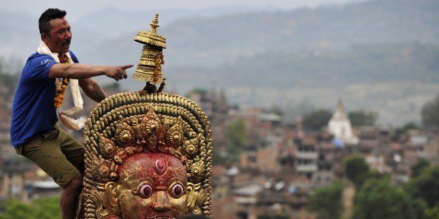 A Nepalese devotee shouts to Hindu and Buddhist residents as they pull a chariot during the Rato (Red) Machindranath Chariot Festival at Bungamati in Lalitpur some 10 km south of Kathmandu on April 24, 2015. The event, celebrated every year to herald good monsoon rains for increased rice harvest, prosperity and good luck, is one of the main festivals observed by both the Buddhist and Hindu communities in Kathmandu. AFP PHOTO / PRAKASH MATHEMA (Photo credit should read PRAKASH MATHEMA/AFP/Getty Images)