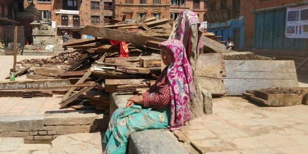 A Nepalese woman sits outdoors after another earthquake in Bhaktapur, Nepal, Tuesday, May 12, 2015. A major earthquake has hit Nepal near the Chinese border between the capital of Kathmandu and Mount Everest less than three weeks after the country was devastated by a quake. (AP Photo/Tashi Sherpa)