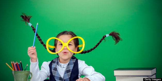 little smart girl wearing eyeglasses and blue pen.