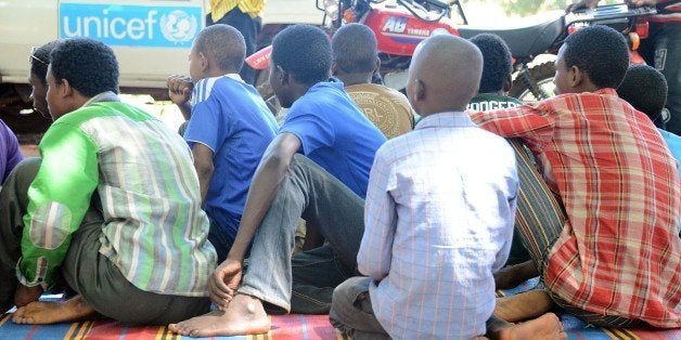 Young fighters sit on a blanket in downtown Bambari after over 350 Central African Republic's child soldiers were released by