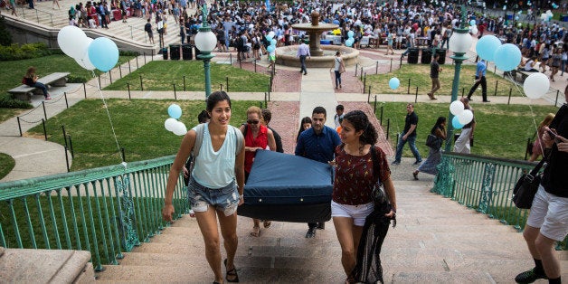 NEW YORK, NY - SEPTEMBER 05: Emma Sulkowicz (L), a senior visual arts student at Columbia University, carries a mattress, with the help of three strangers who met her moments before, in protest of the university's lack of action after she reported being raped during her sophomore year on September 5, 2014 in New York City. Sulkowicz has said she is committed to carrying the mattress everywhere she goes until the university expels the rapist or he leaves. The protest is also doubling as her senior thesis project. (Photo by Andrew Burton/Getty Images)