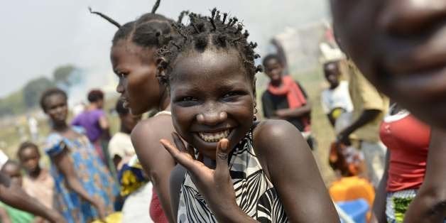 A woman smiles as internally-displaced people (IDPs) wait for water at the IDP camp near the international airport in Bangui