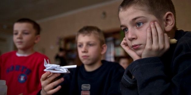 In a picture taken on Saturday, March 7, 2015, a boy holds a paper tank at a children's home, in Khartsyzk, Ukraine. A brutal conflict between Russia-backed rebels and Ukrainian government troops has affected more than 1.7 million children on both sides of the front line, according to the UNâs childrenâs agency, with some of them sent to orphanages when their parents got killed or went to fight for the rebels, while some parents gave up their foster children because they were no longer receiving benefits for them. (AP Photo/Vadim Ghirda)
