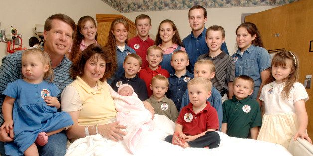 FILE - In this Aug. 2, 2007 file photo, Michelle Duggar, left, is surrounded by her children and husband Jim Bob, second from left, after the birth of her 17th child in Rogers, Ark. No. 19 caught Michelle Duggar by surprise. The 42-year-old mom of 18 noticed that she wasn't losing weight, even though she and husband Jim Bob were on Weight Watchers, and her youngest child, 8-month-old Jordyn-Grace, was fussing while nursing. In the past, she found a fussy infant meant a change in breast milk that came with pregnancy. (AP Photo/ Beth Hall, File)