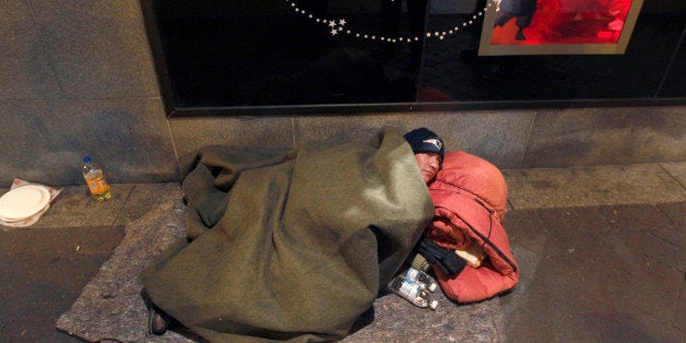 In this Monday night Dec. 12, 2011 photo, John Filliger, of Houston, who said he has been homeless for the past five years, lies wrapped in bedding on Washington Street in the heart of the Downtown Crossing area of Boston. Filliger, who was offered a bed in a shelter for the evening, stayed on the street for the night and was counted in the annual homeless census. (AP Photo/Charles Krupa)