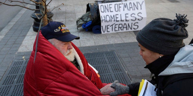 In this Wednesday, Nov. 20, 2013 photo homeless Korean War veteran Thomas Moore, 79, left, speaks with Boston Health Care for the Homeless street team outreach coordinator Romeena Lee on a sidewalk in Boston. Moore, who said he accidentally killed his best friend with a phosphorous grenade during one firefight and spent months afterward at Walter Reed Army Medical Center in Washington, also said he has no interest in getting a government-subsidized apartment. (AP Photo/Steven Senne)