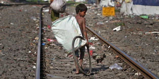 An Indian ragpicker searches for reusable materials from garbage thrown on railway tracks in Gauhati, India, Friday, Oct. 10, 2014. Pakistan's Malala Yousafzai became the youngest Nobel winner ever as she and Kailash Satyarthi of India won the Nobel Peace Prize on Friday, Oct. 10, 2014, for working to protect children from slavery, extremism and child labor at great risk to their own lives. (AP Photo/Anupam Nath)