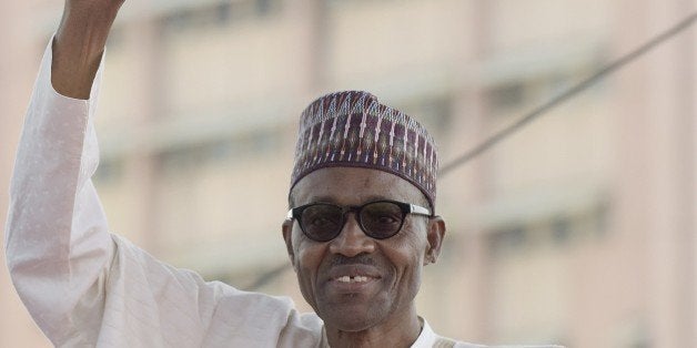 Nigerian President Mohammadu Buhari raises his hand to greet the crowd before taking oath of office at the Eagles Square in Abuja, on May 29, 2015. Buhari, 72, defeated Goodluck Jonathan in March 28 elections -- the first time in Nigeria's history that an opposition candidate had beaten a sitting president. AFP PHOTO/PIUS UTOMI EKPEI (Photo credit should read PIUS UTOMI EKPEI/AFP/Getty Images)