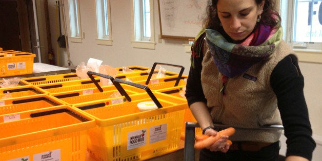 In this Dec. 16, 2014 photo, Sam Rothberg, packing house supervisor for the Intervale Food Hub in Burlington, Vt., packs carrots into weekly deliveries of food produced by area farmers. Food hubs around the country are getting more fresh, locally produced food out to consumers and giving farmers another avenue for expanding their sales. (AP Photo/Lisa Rathke)