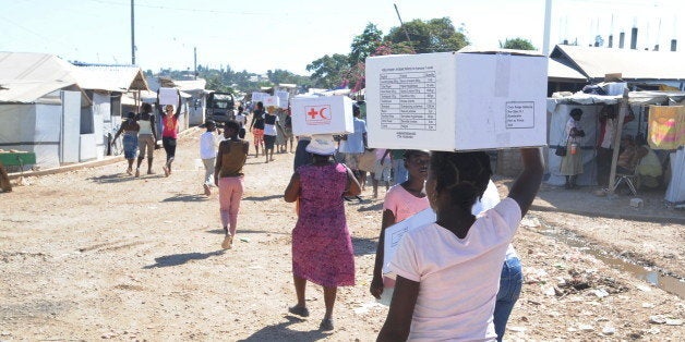 People walk away after receiving medical kits to aid in the prevention of cholera on February 11, 2011 from the International Red Cross in a city tent in Delmas, a suburb of Port-au-Prince. AFP PHOTO/Thony BELIZAIRE (Photo credit should read THONY BELIZAIRE/AFP/Getty Images)