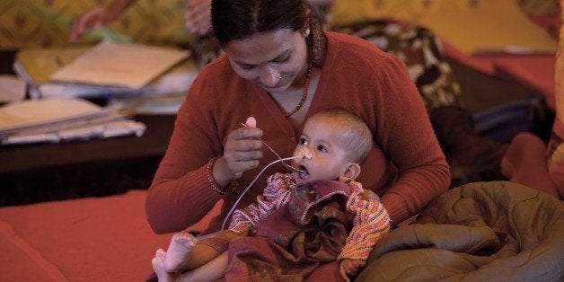 A Nepalese woman feeds her baby at the Nepali Military hospital in Kathmandu on April 29, 2015. Israel sent some 250 soldiers to Nepal to help search for casualties and build a field hospital following the 7.8-magnitude earthquake. Desperate people in Nepal clashed with riot police and seized supplies of bottled water in the capital April 29 as anger boiled over among survivors of an earthquake that killed more than 5,000 people. AFP PHOTO / MENAHEM KAHANA (Photo credit should read MENAHEM KAHANA/AFP/Getty Images)