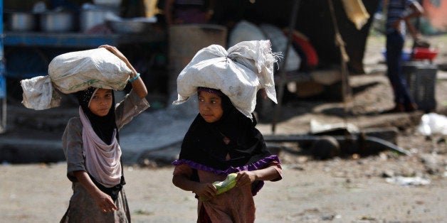 Indian child laborers carry sacks of vegetable leftovers collected from a wholesale market to be sold in their shantytown, on the World Day against Child Labor, on the outskirts of Jammu, India, Friday, June 12, 2015. Despite the country's rapid economic growth, child labor remains widespread in India, where an estimated 13 million children work, with laws meant to keep kids in school and out of the workplace routinely flouted. (AP Photo/Channi Anand)