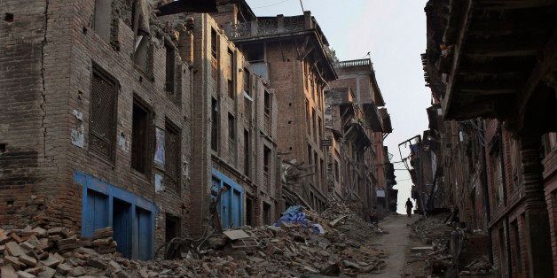 A Nepalese man walks through a path cleared with rubbles of damaged houses one month after the deadly 7.8 magnitude earthquake in Kathmandu, Nepal Monday, May 25, 2015. Two powerful earthquakes devastated Nepal on April 25 and May 12, killing nearly 8,700 people and injuring 16,800 others. The quakes and aftershocks also triggered many landslides in the Himalayan nation, which boasts eight of the world's highest mountains gets about half a million tourists every year, with many coming to trek the Himalayan nation's scenic mountain trails. (AP Photo/Niranjan Shrestha)