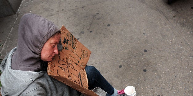 NEW YORK, NY - MAY 18: A homeless woman rests while panhandling along Eighth Avenue in Manhattan on May 18, 2015 in New York City. As many parts of once seedy New York City have been transformed into family and shopping friendly environments, 8th Avenue near the Port Authority bus station is one of the last hold-outs to old gritty Manhattan. Last week a man was shot by police after he attacked numerous people with a hammer along a stretch of the street. There is a high police presence along the street and fights and arrests for vagrancy are common. (Photo by Spencer Platt/Getty Images)