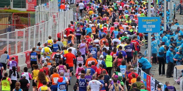 LONDON, ENGLAND - APRIL 26: Runners make their way through Canary Wharf during the Virgin Money London Marathon on April 26,