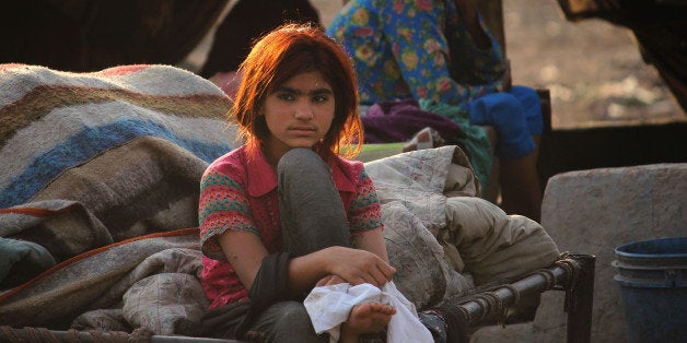 LAHORE, PUNJAB, PAKISTAN - 2014/04/24: Pakistani gypsy children playing in the dry river ravi near their slum home on the eve