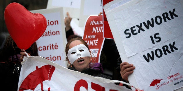 FILE - In this Nov.29, 2013 file photo, a French sex worker demonstrates outside the National Assembly in Paris, France. A French bill aimed at decriminalizing prostitutes and fining their customers is being turned upside down by the Senate, led by the conservative opposition. The proposed bill, aims at introducing a 1,500-euro (about $1,623) fine for customers and decriminalizing the estimated 40,000 prostitutes in France. (AP Photo/Christophe Ena, File)