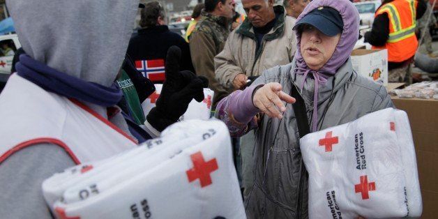 Galina Quacinella, right, gets some blankets for herself and her husband at a Red Cross aid station in Staten Island, New York, Sunday, Nov. 4, 2012. With overnight temperatures sinking into the 30s, hundreds of thousands of homes and businesses are still without electricity in the aftermath of Superstorm Sandy. (AP Photo/Seth Wenig)