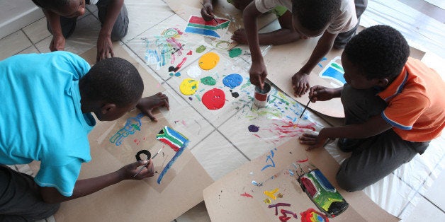 Local school children, start painting while attending an artists workshop at the Art Smart Brand center, in Alexandra Township north of Johannesburg Tuesday, Aug. 25, 2015. The learners experienced working alongside professional artists and had to express their skills at the only existing art center in the township. (AP Photo/Denis Farrell)