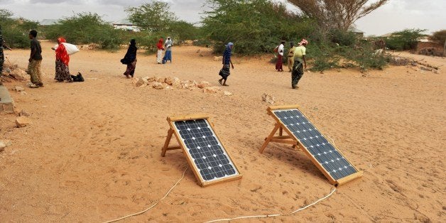 TO GO WITH STORY BY JEAN MARC MOJON Residents of the central Somali town of Wisil walk past solar panels laid out in front of