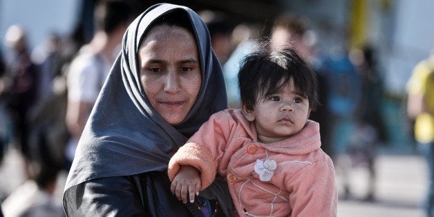 Refugees and migrants disembark from the Eleftherios Venizelos goverment chartered ferry in the port of Piraeus on October 1